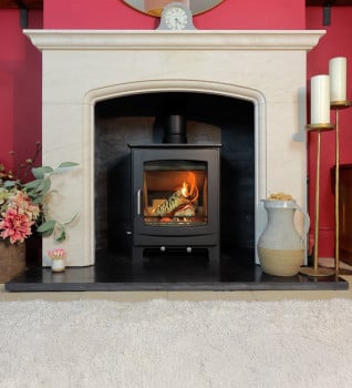 Woodford Turing 5 Multifuel Stove Shwon in a Chatsworth Limestone Surround and tiled chamber